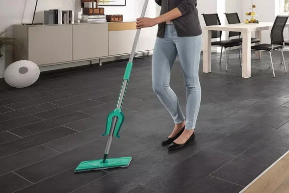 Person wischt Fliesen mit Wischmopp